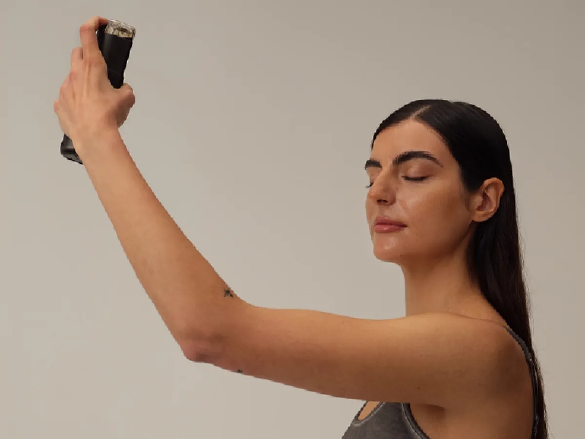 Woman sprays Tanrevel self-tanner on her face