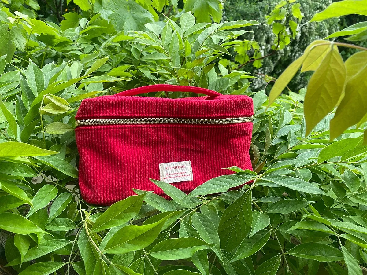 Set d'icônes de soins et de maquillage Clarins photographié dans la verdure