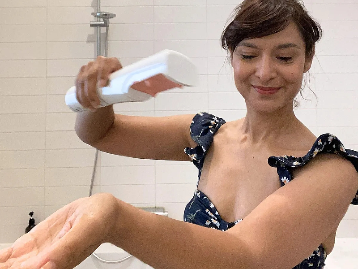 IONIQ skincare experience report: Woman tests the ONE Sprayer with SPF 50 sun cream on her arm