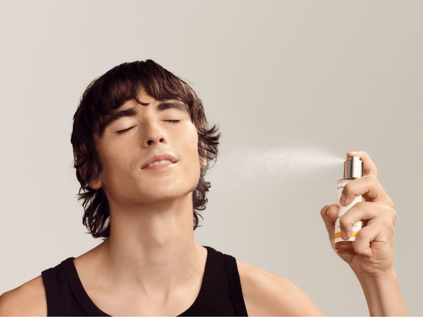 Mann sprüht das Gesichtstonikum von Dr. Hauschka ins Gesicht