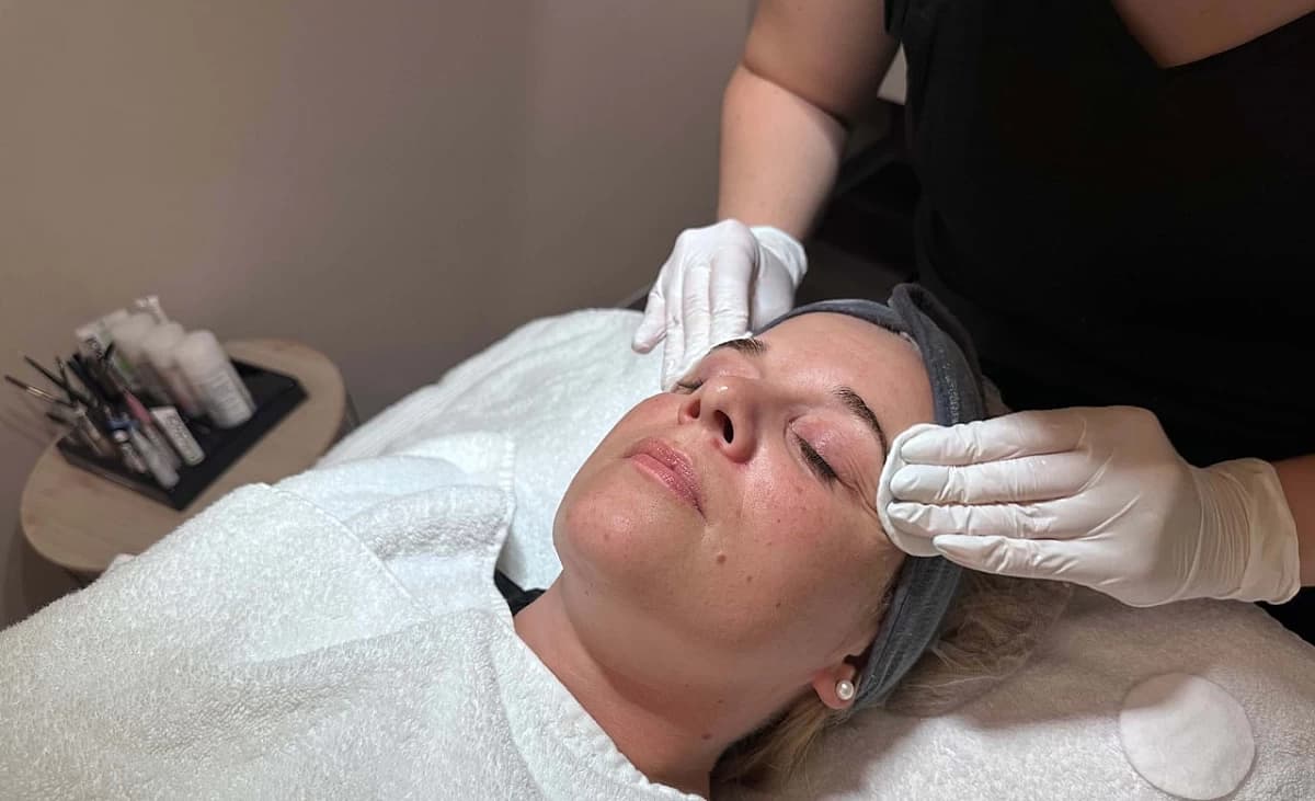 Toner is applied to the client's face with cotton pads.